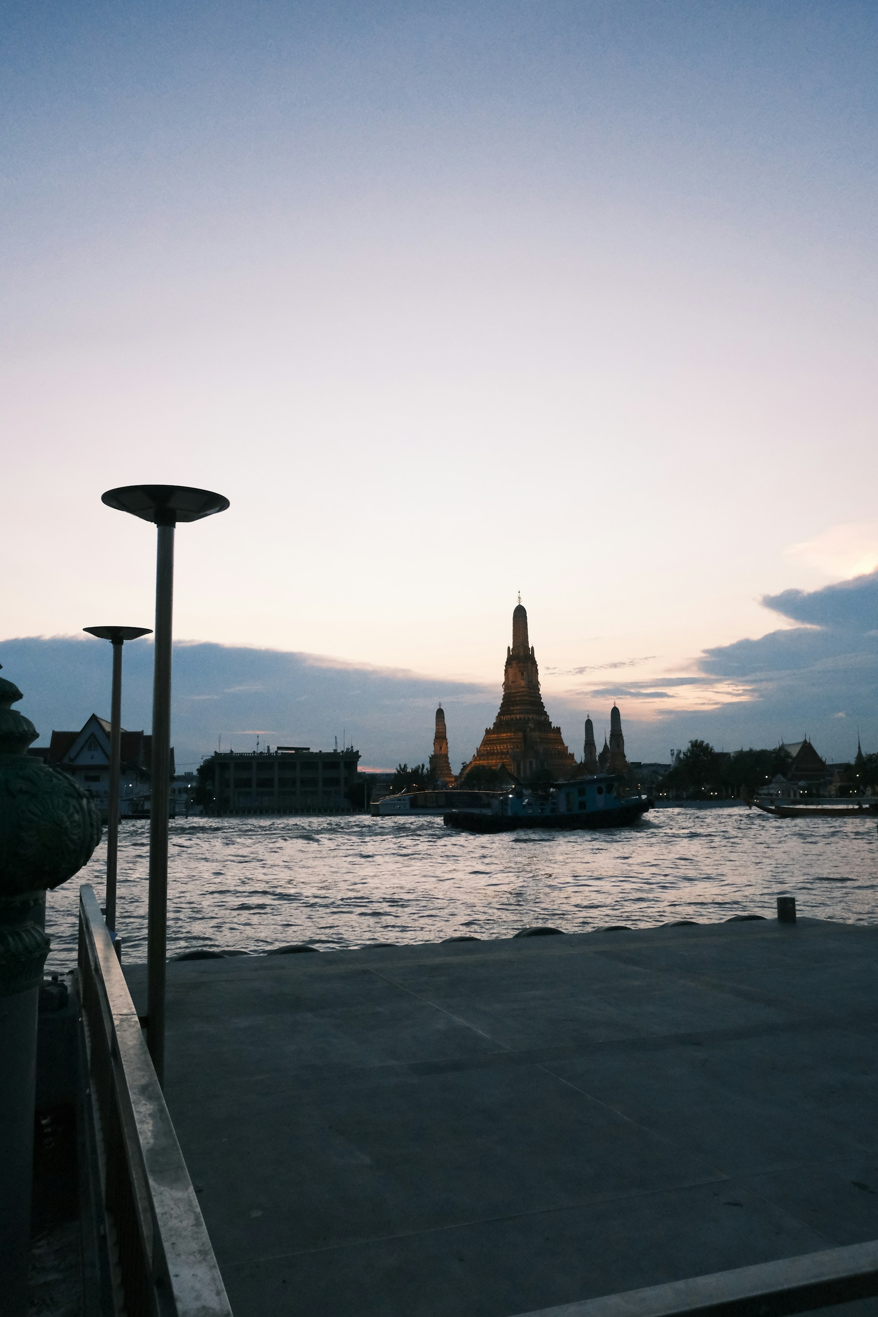 Wat Arun temple beside the Chao Phraya River in Bangkok at dusk